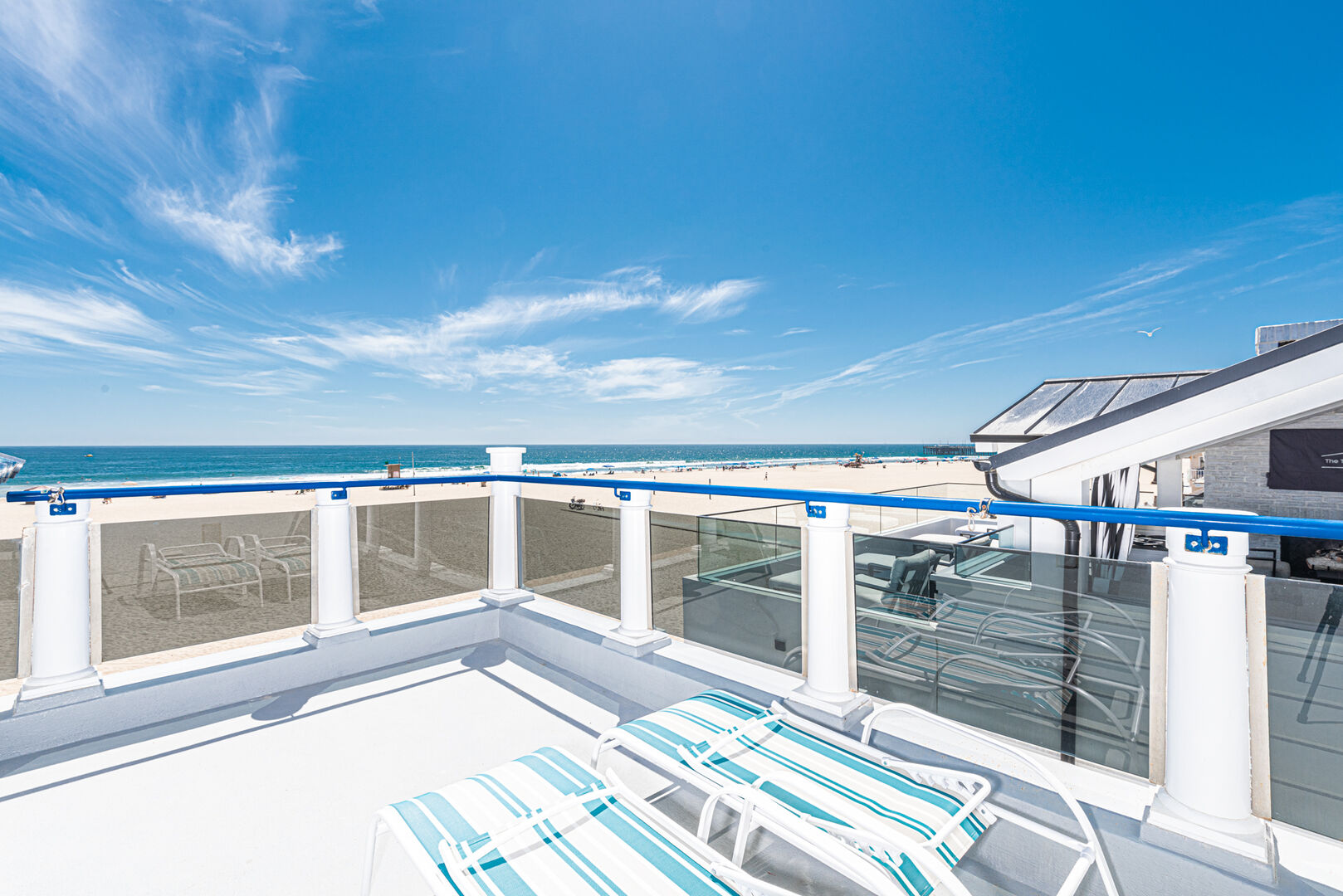 A view of the chaise lounges and the beach on the roof lanai